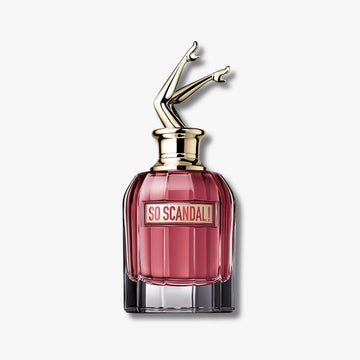 Perfume bottle labeled 'So Scandal' with a gold cap on a light gray background