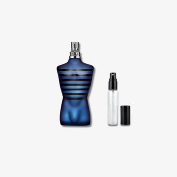 Jean Paul Gaultier Ultra Male Decants Blue perfume bottle with black stripes and smaller clear bottle on a white background